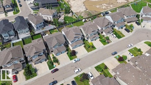 Residential street featuring single-family homes with asphalt shingle roofs, attached garages, paved driveways, and manicured front lawns - 17304 73 Street Nw, Edmonton, AB - Other