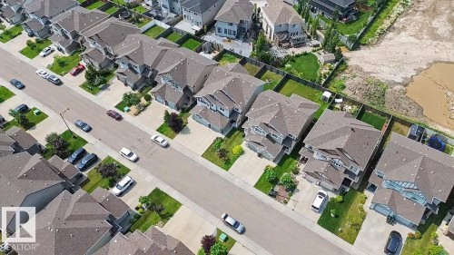 Aerial perspective of a residential street featuring multiple detached properties with grey shingle roofs - 17304 73 Street Nw, Edmonton, AB - 