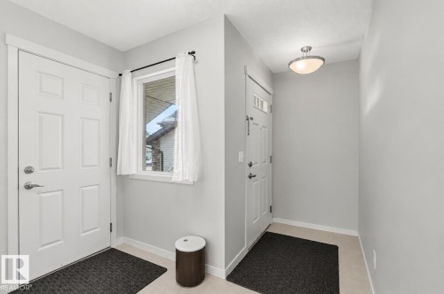 Foyer featuring light gray wall paint, tiled flooring, an entry door with glass inserts, and a flush-mount ceiling light fixture - 17304 73 Street Nw, Edmonton, AB - Indoor Photo Showing Other Room