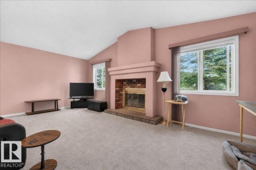 Vaulted ceiling, brick fireplace with hearth, multiple windows, and light-colored carpeting - 121 51205 Range Road 195, Rural Beaver County, AB - Indoor With Fireplace