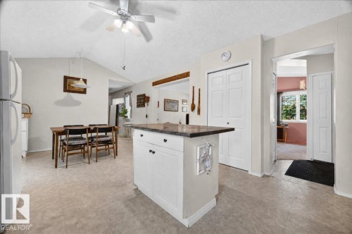 Kitchen island with a dark countertop and white cabinetry - 121 51205 Range Road 195, Rural Beaver County, AB - Indoor Photo Showing Kitchen