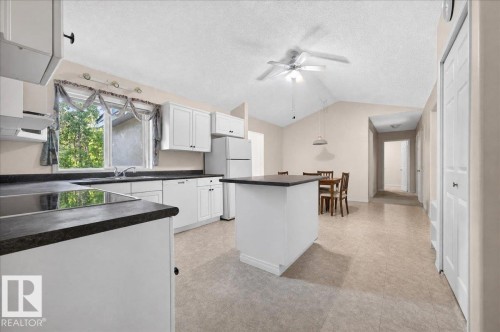 Kitchen featuring white cabinetry, dark countertops, a center island, and a vaulted ceiling - 121 51205 Range Road 195, Rural Beaver County, AB - Indoor Photo Showing Kitchen