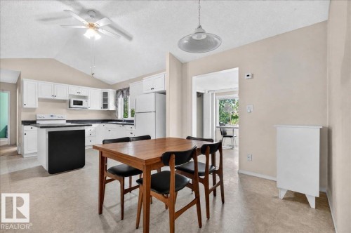 Vaulted ceiling with a ceiling fan, white cabinetry with black countertops, and light-toned flooring - 121 51205 Range Road 195, Rural Beaver County, AB - Indoor