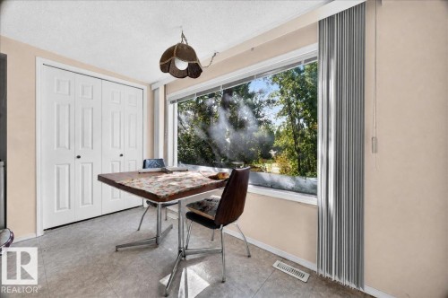 Recessed ceiling with an overhead light fixture, large window with vertical blinds, and bi-fold panel doors - 121 51205 Range Road 195, Rural Beaver County, AB - Indoor