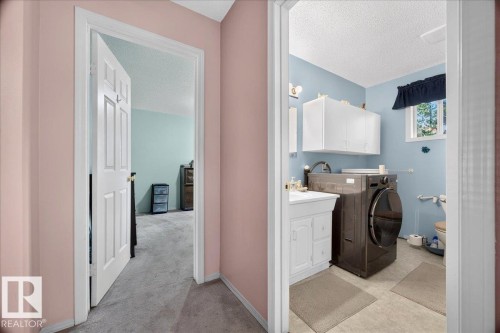 Full-size laundry appliances, white vanity with cabinet storage, window for natural light, and overhead white cabinetry - 121 51205 Range Road 195, Rural Beaver County, AB - Indoor Photo Showing Laundry Room
