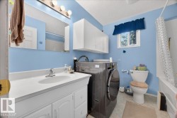 White vanity with integrated sink, chrome faucet, wall-mounted mirror, and overhead lighting fixture - 