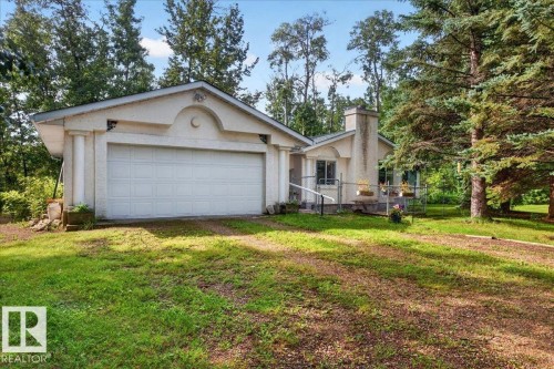 Attached two-car garage, stucco exterior, mature trees, and a visible chimney feature - 121 51205 Range Road 195, Rural Beaver County, AB - Outdoor