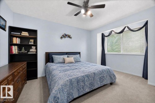 Window with blinds, wall-mounted ceiling fan, built-in shelving, and light-toned carpet flooring - 121 51205 Range Road 195, Rural Beaver County, AB - Indoor Photo Showing Bedroom
