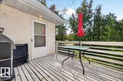 Wood-plank deck with a white painted finish, white railing, and exterior door with screen - 