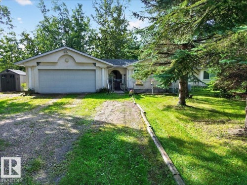 Attached garage, gravel driveway, mature trees, lawn, and an exterior shed - 121 51205 Range Road 195, Rural Beaver County, AB - Outdoor