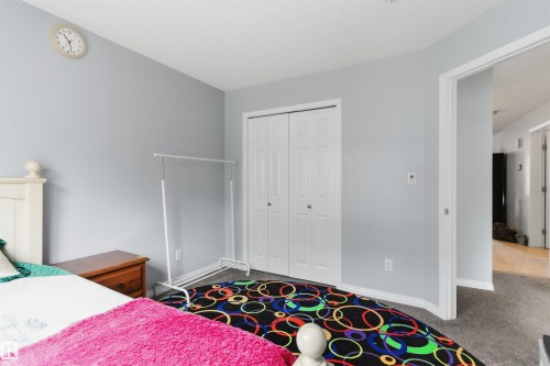 White bi-fold closet doors, light gray wall paint, and gray carpet flooring - #30 3305 Orchards Link Sw Sw, Edmonton, AB 