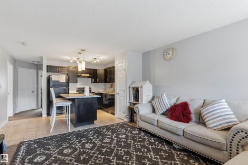 Kitchen with dark cabinetry and a peninsula with seating - #30 3305 Orchards Link Sw Sw, Edmonton, AB 