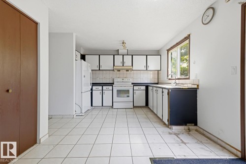 Kitchen featuring white tile flooring, white appliances, and a window above the sink - 3515 43 Avenue Nw, Edmonton, AB - Indoor Photo Showing Kitchen