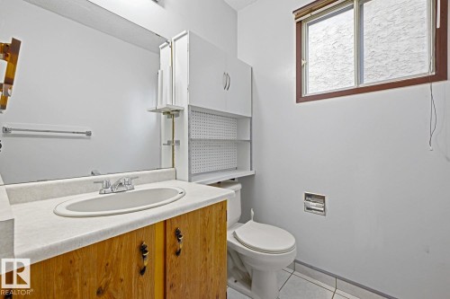 Wood-finish vanity with an integrated basin and chrome faucet - 3515 43 Avenue Nw, Edmonton, AB - Indoor Photo Showing Bathroom