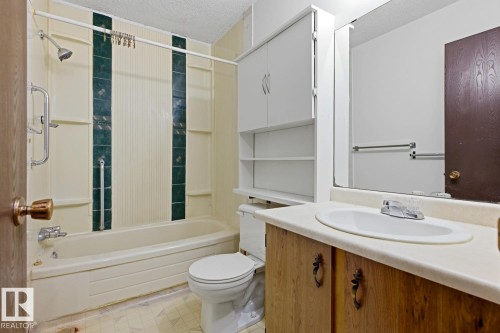 Built-in vanity with integrated sink, full-width mirror, and overhead storage cabinetry - 3515 43 Avenue Nw, Edmonton, AB - Indoor Photo Showing Bathroom