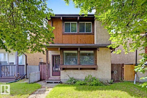 Two-story exterior with stucco and wood-panel accents, featuring a prominent front window and entry door - 3515 43 Avenue Nw, Edmonton, AB - Outdoor