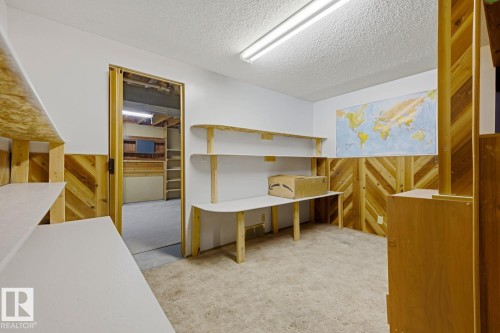Built-in shelving, wood-finish wall paneling, and a workstation with a built-in desk - 3515 43 Avenue Nw, Edmonton, AB - Indoor Photo Showing Other Room