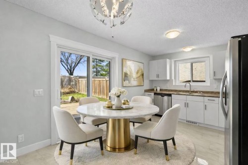 Kitchen with white cabinetry, stainless steel appliances, and a light-toned countertop - 4209 25 Avenue Nw, Edmonton, AB - Indoor Photo Showing Dining Room