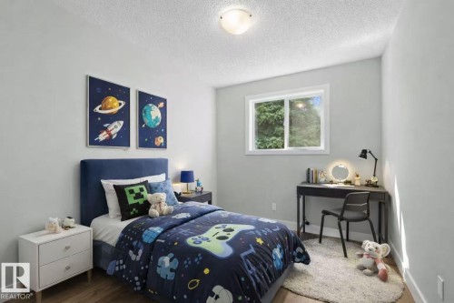 Light-filled room featuring a double-pane window, wood-finish flooring, and a flush-mount ceiling light fixture - 4209 25 Avenue Nw, Edmonton, AB - Indoor Photo Showing Bedroom