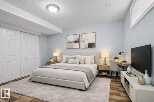Wood-finish flooring, white paneled closet doors, and a window opening - 4209 25 Avenue Nw, Edmonton, AB - Indoor Photo Showing Bedroom