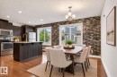 Wood-finish flooring, recessed lighting, and a kitchen island with an undermount sink and gooseneck faucet - #69 3625 144 Av Nw, Edmonton, AB  - Indoor 