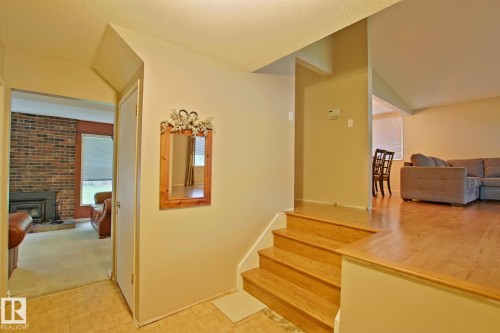 Wood-finish flooring, brick-clad fireplace, and integrated staircase - 18107 89 Avenue Nw, Edmonton, AB - Indoor With Fireplace