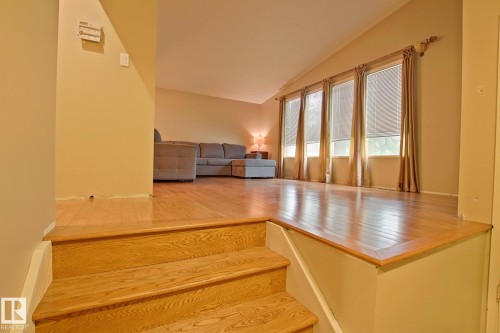 Hardwood flooring throughout, multiple large windows, and a vaulted ceiling - 18107 89 Avenue Nw, Edmonton, AB - Indoor Photo Showing Other Room