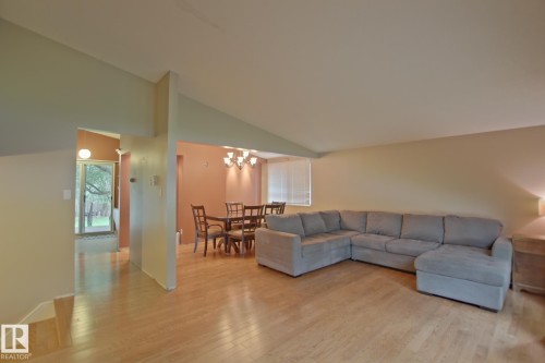Light wood-finish flooring throughout, with a dining area featuring a chandelier - 18107 89 Avenue Nw, Edmonton, AB - Indoor Photo Showing Living Room