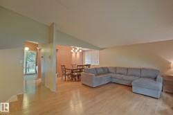 Light wood-finish flooring throughout, with a dining area featuring a chandelier - 