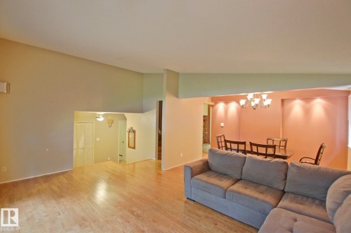 Wood-finish flooring throughout, with a semi-open concept design, vaulted ceiling, and recessed lighting in the dining area - 18107 89 Avenue Nw, Edmonton, AB - Indoor Photo Showing Living Room