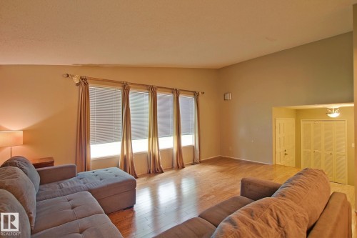 Vaulted ceiling with a flush-mount light fixture, wood-finish flooring, and multiple windows - 18107 89 Avenue Nw, Edmonton, AB - Indoor