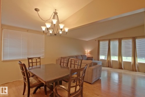 Vaulted ceiling, wood-finish flooring, and multiple windows with blinds - 18107 89 Avenue Nw, Edmonton, AB - Indoor Photo Showing Dining Room