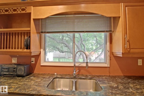 Double stainless steel sink with a high-arch faucet, set into a stone-finish countertop - 18107 89 Avenue Nw, Edmonton, AB - Indoor Photo Showing Kitchen With Double Sink