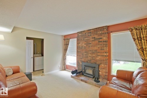 Brick-faced fireplace with a metal insert and hearth - 18107 89 Avenue Nw, Edmonton, AB - Indoor Photo Showing Living Room With Fireplace
