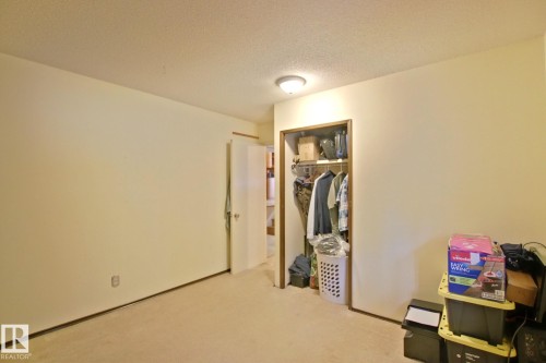Recessed closet with built-in shelving, neutral wall paint, and overhead flush-mount lighting - 18107 89 Avenue Nw, Edmonton, AB - Indoor Photo Showing Other Room