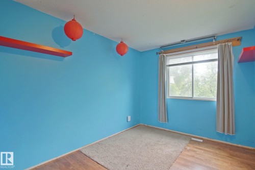 Hardwood-finish flooring with partial carpeting, a window with drapery, and a wall-mounted shelf - 18107 89 Avenue Nw, Edmonton, AB - Indoor Photo Showing Other Room