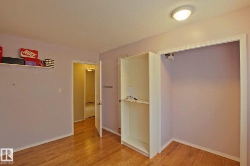 Wood-finish flooring, built-in shelving, flush mount ceiling light, and interior doorway - 18107 89 Avenue Nw, Edmonton, AB - Indoor Photo Showing Other Room