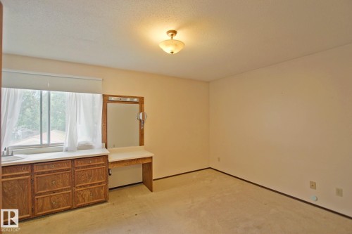 Built-in wood vanity with integrated sink, a large mirror, and overhead lighting - 18107 89 Avenue Nw, Edmonton, AB - Indoor Photo Showing Other Room