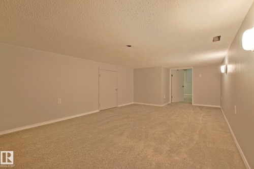 Expansive carpeted area with neutral walls, recessed lighting, and wall sconces - 18107 89 Avenue Nw, Edmonton, AB - Indoor Photo Showing Other Room