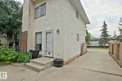 Stucco exterior with concrete steps, a wood privacy fence, and a concrete driveway - 