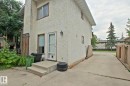 Stucco exterior with concrete steps, a wood privacy fence, and a concrete driveway - 18107 89 Avenue Nw, Edmonton, AB  - Outdoor With Exterior 