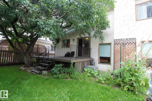 Outdoor deck with metal railings and steps, featuring a sliding glass door and an adjacent window - 18107 89 Avenue Nw, Edmonton, AB - Outdoor