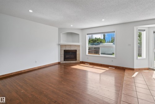 Hardwood-finish flooring with recessed lighting - 1707 37A Avenue Nw, Edmonton, AB - Indoor Photo Showing Living Room With Fireplace