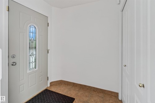 White entry door with decorative glass insert - 1707 37A Avenue Nw, Edmonton, AB - Indoor Photo Showing Other Room