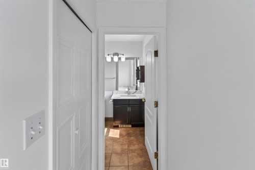 Bathroom featuring a dark wood vanity with a white countertop, vessel sink, and three-light fixture - 1707 37A Avenue Nw, Edmonton, AB - Indoor