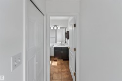 Bathroom featuring a dark wood vanity with a white countertop, vessel sink, and three-light fixture - 