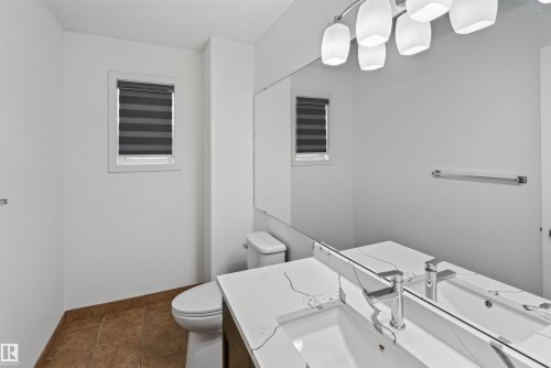 Modern vanity with an integrated sink, polished chrome faucet, and a quartz-finish countertop - 1707 37A Avenue Nw, Edmonton, AB - Indoor Photo Showing Bathroom