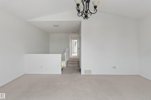 Vaulted ceiling, ceiling-mounted chandelier, and carpeting - 1707 37A Avenue Nw, Edmonton, AB - Indoor Photo Showing Other Room