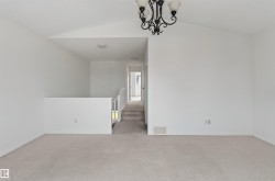 Vaulted ceiling, ceiling-mounted chandelier, and carpeting - 