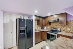 Kitchen featuring wood-finish cabinetry, patterned tile backsplash, and light-toned countertops - 